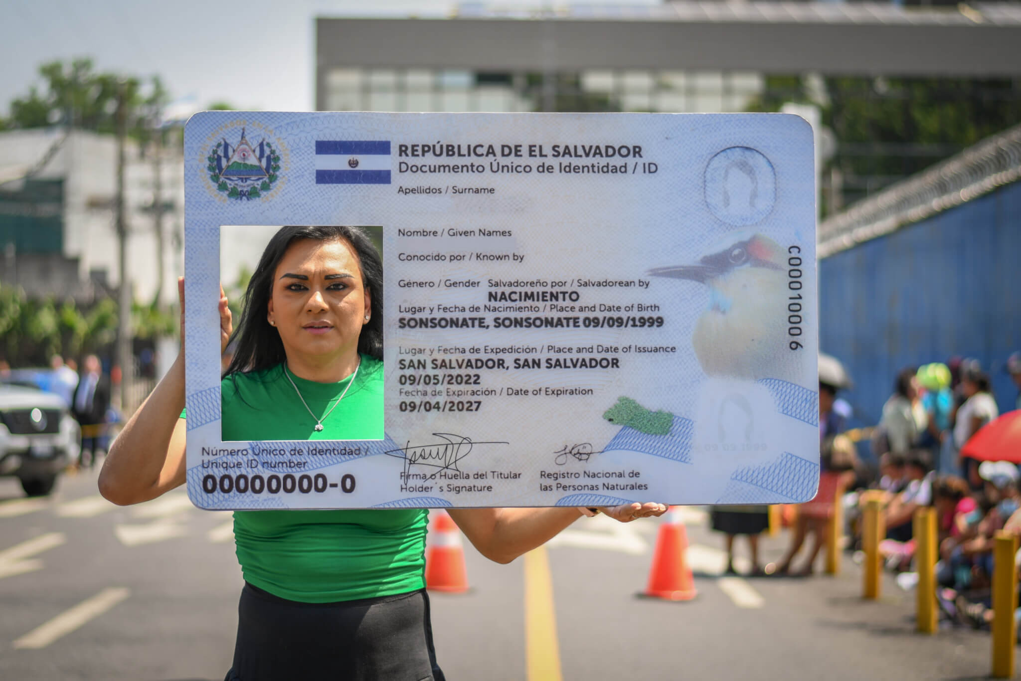 Mónica Linares, directrice de l'association ASPIDH, tient une carte d'identité géante dans une manifestation pour le droit au changement de nom au Salvador.
